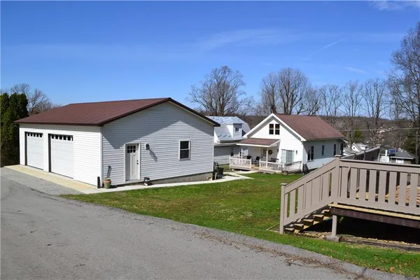 a view of backyard with a barn and a large tree