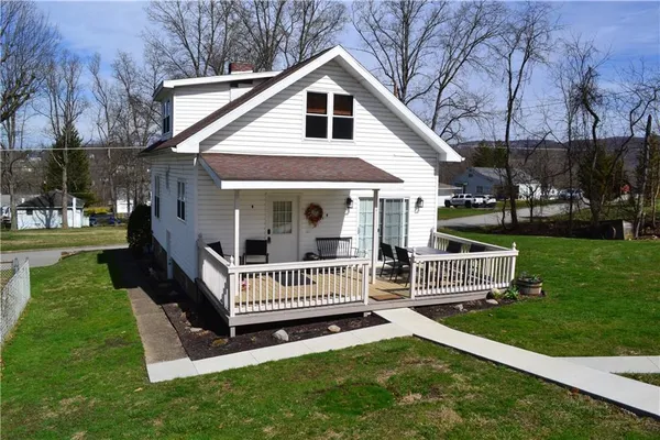 a view of a house with a yard and deck