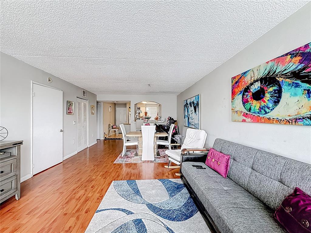 6065 Northwest 186th Street, Unit 312 Hialeah, FL 33015 - Photo 3 of 17 a living room with furniture and a wooden floor