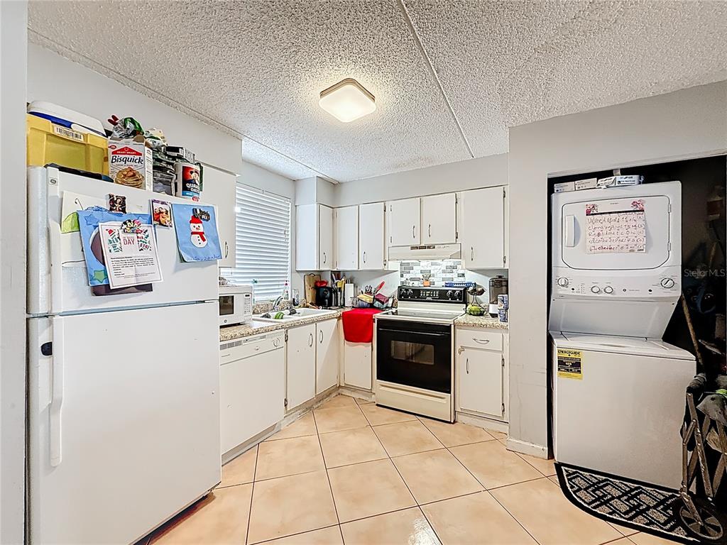 6065 Northwest 186th Street, Unit 312 Hialeah, FL 33015 - Photo 7 of 17 a kitchen with a refrigerator and white cabinets