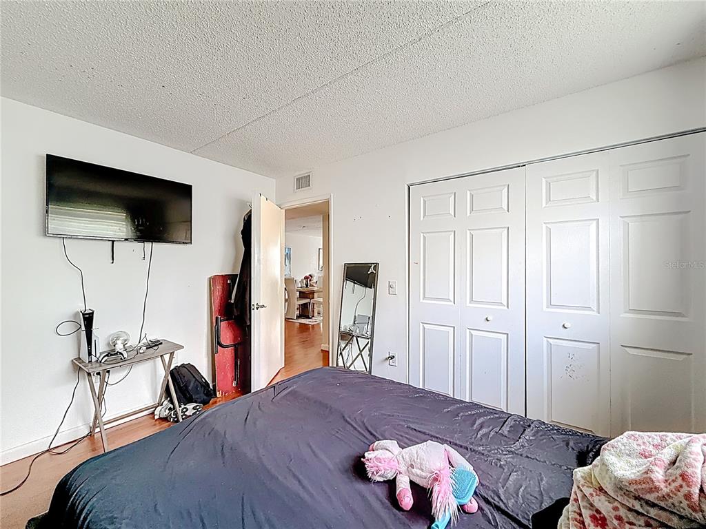 6065 Northwest 186th Street, Unit 312 Hialeah, FL 33015 - Photo 8 of 17 a bedroom with a bed and a flat screen tv