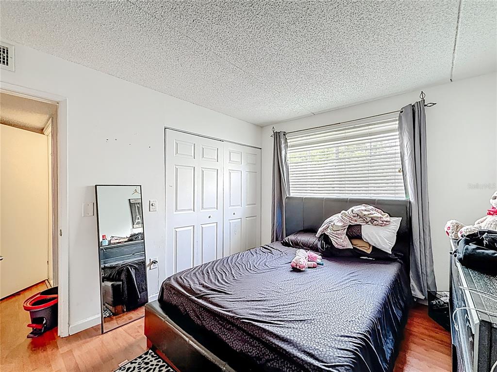 6065 Northwest 186th Street, Unit 312 Hialeah, FL 33015 - Photo 9 of 17 a bedroom with a bed and wooden floor