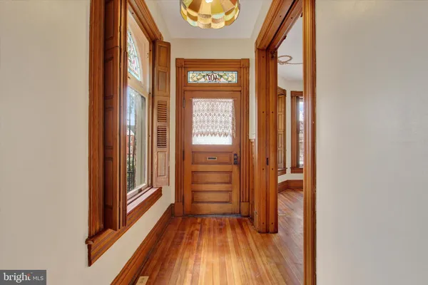 a view of a hallway with wooden floor and entryway