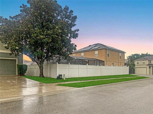 a view of a big house in a big yard with large trees