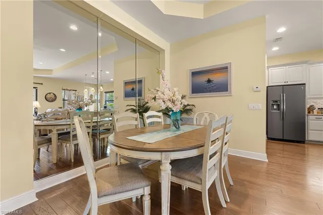 a living room with furniture a chandelier and a dining table