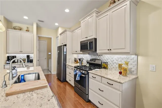 a kitchen with stainless steel appliances granite countertop a lot of counter space a stove and a refrigerator