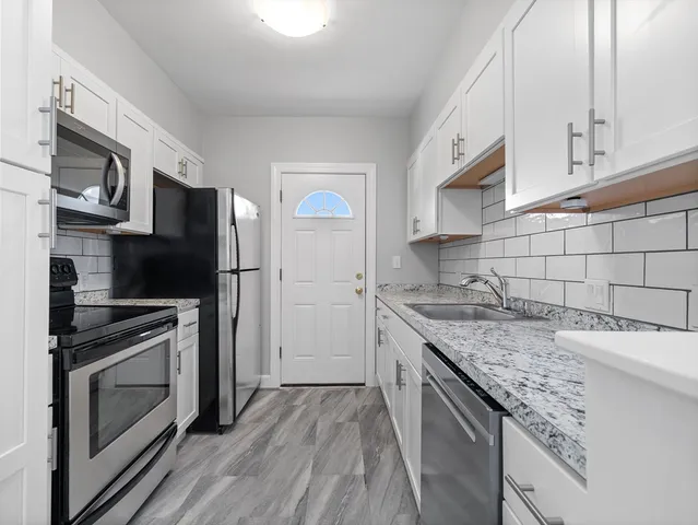 a kitchen with granite countertop stainless steel appliances and wooden cabinets