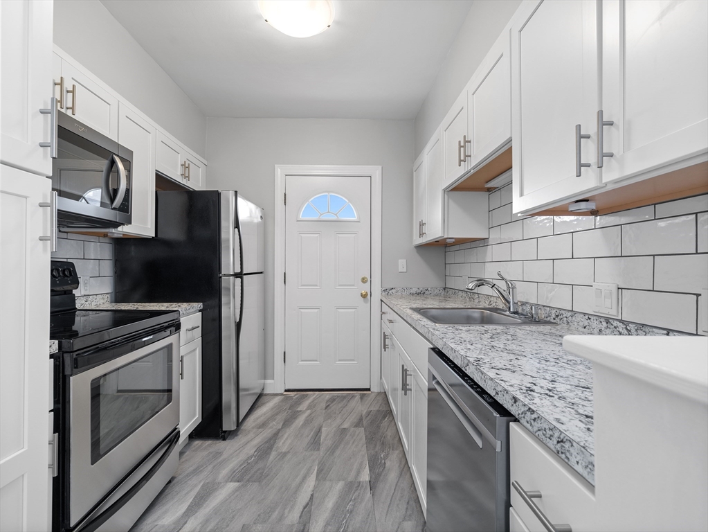 a kitchen with granite countertop stainless steel appliances and wooden cabinets