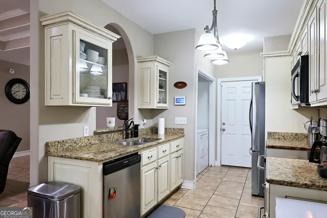 a kitchen with a stove a sink and a refrigerator
