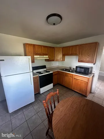 a kitchen with stainless steel appliances granite countertop a sink and a refrigerator