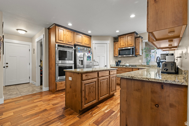 4557 North Ranch Road East Tooele, UT 84074 - Photo 11 of 43 Kitchen featuring wood-finish flooring, recessed lighting, wood cabinetry, stone countertops, and stainless steel appliances