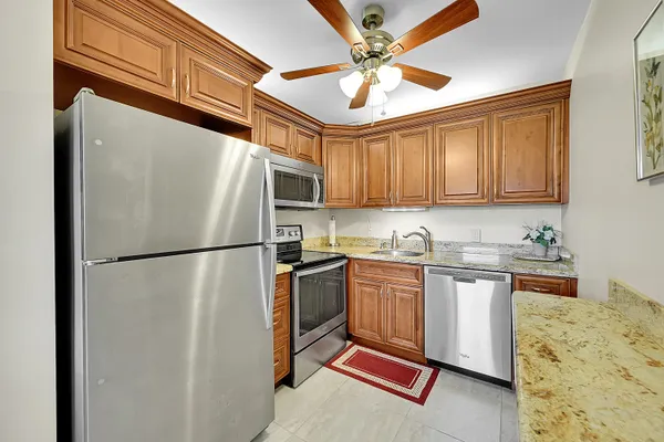 a kitchen with stainless steel appliances granite countertop a sink and cabinets