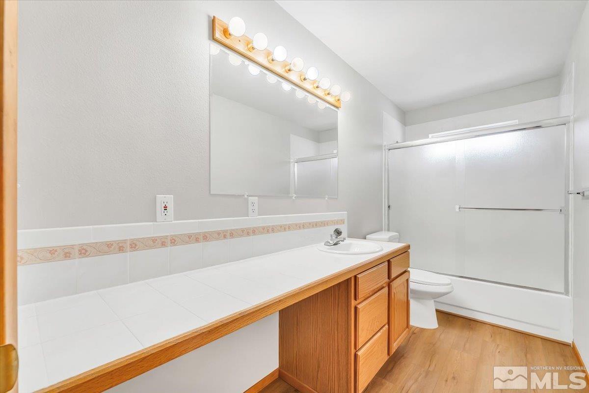 155 Andrew Lane Reno, NV 89521 - Photo 12 of 35 a bathroom with a sink a toilet a mirror and vanity