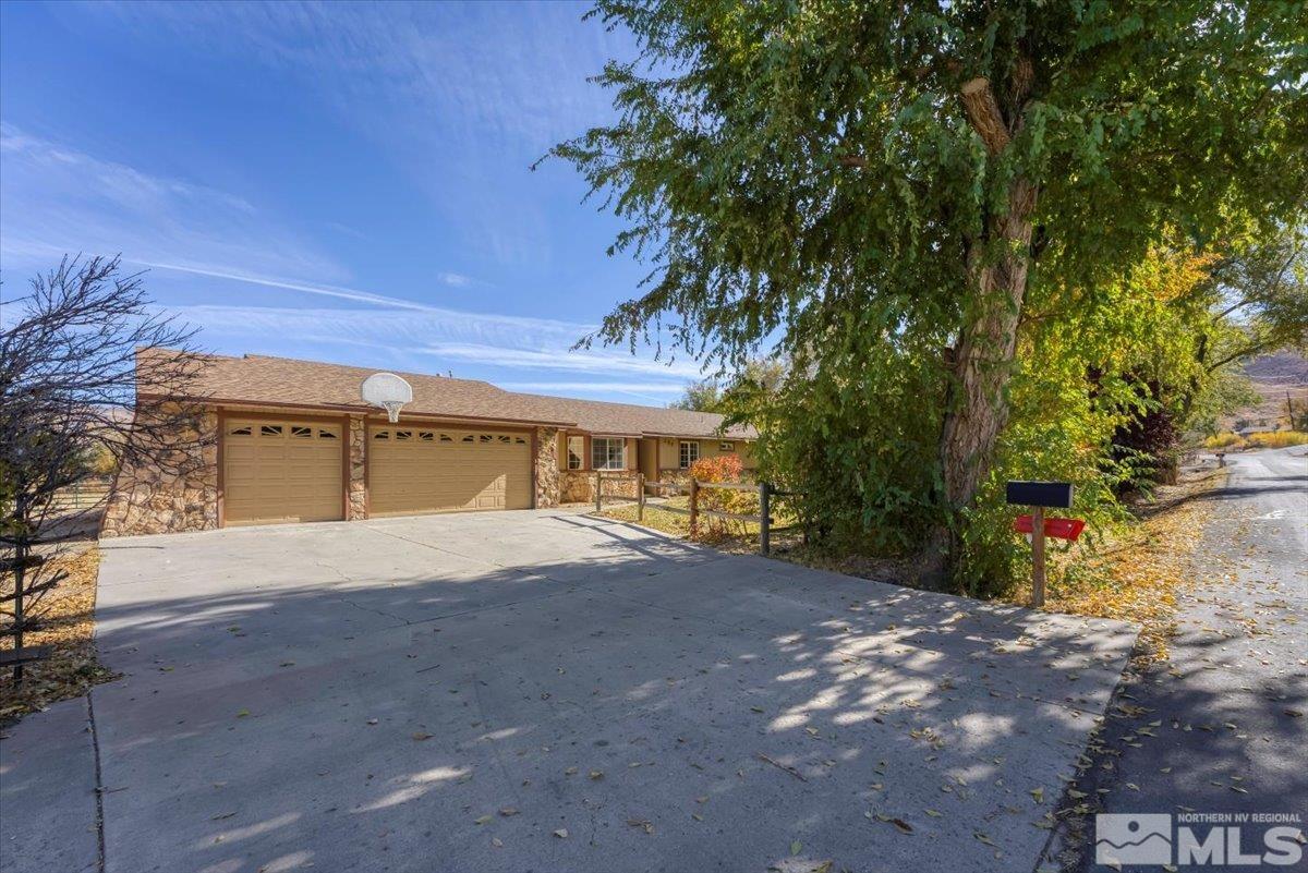 155 Andrew Lane Reno, NV 89521 - Photo 2 of 35 a front view of a house with a yard and a garage