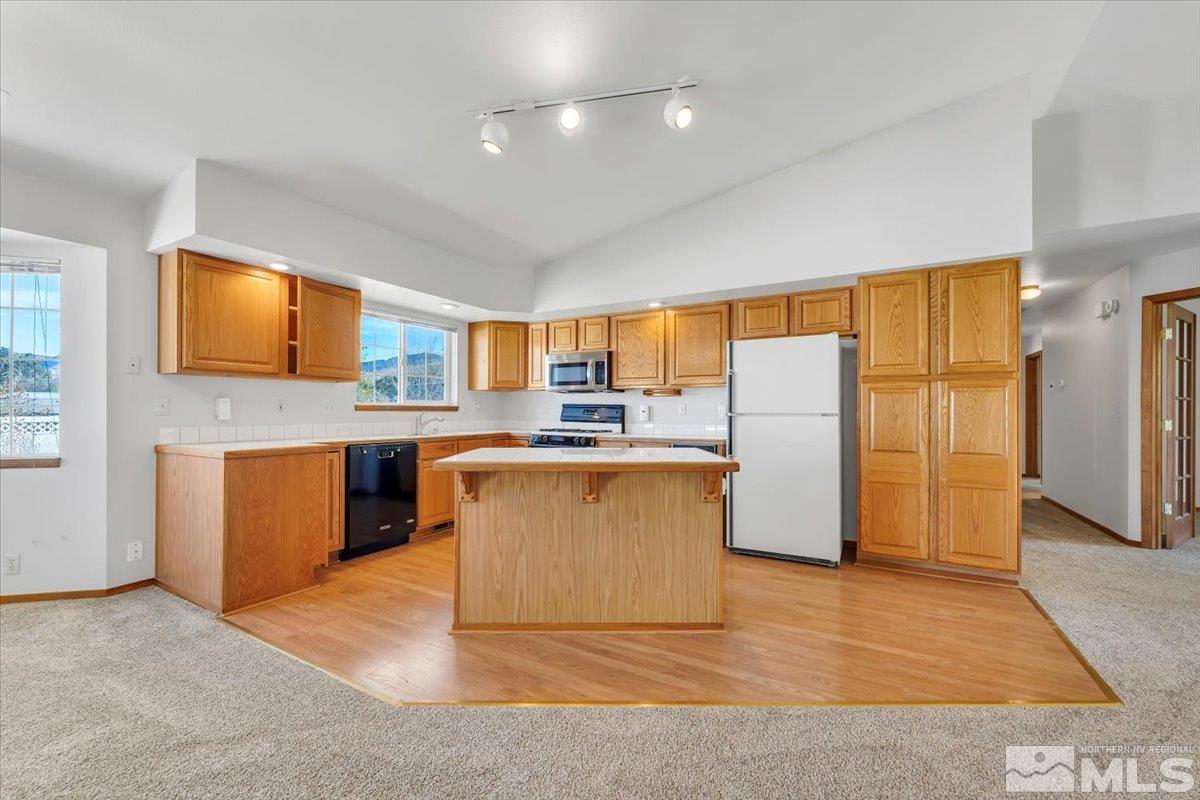 155 Andrew Lane Reno, NV 89521 - Photo 6 of 35 a kitchen with stainless steel appliances granite countertop a refrigerator a sink a stove a microwave a counter space and cabinets