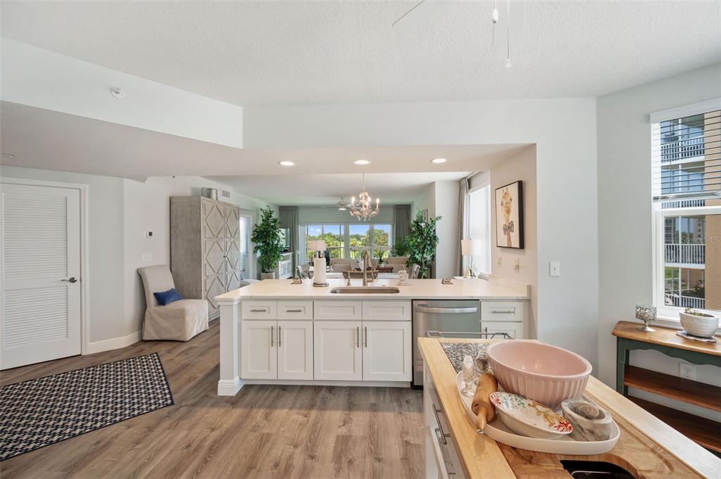 960 Starkey Road, Unit 8206 Largo, FL 33771 - Photo 15 of 71 a large white kitchen with a stove a sink dishwasher a dining table and chairs with wooden floor