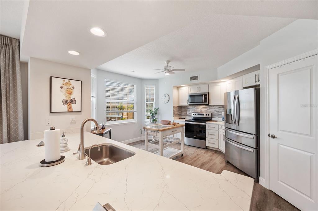 960 Starkey Road, Unit 8206 Largo, FL 33771 - Photo 8 of 71 a kitchen with stainless steel appliances kitchen island granite countertop a refrigerator and a stove top oven