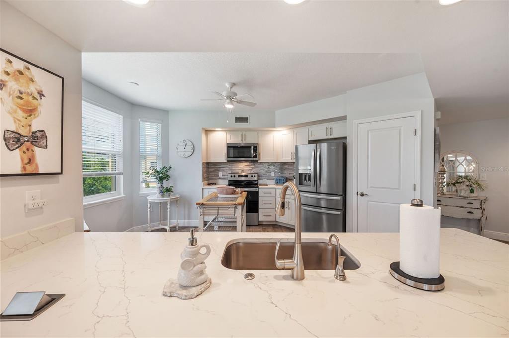 960 Starkey Road, Unit 8206 Largo, FL 33771 - Photo 9 of 71 a kitchen with stainless steel appliances granite countertop a sink and a refrigerator