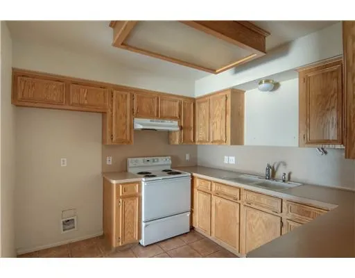 a kitchen with a sink dishwasher a stove and white cabinets