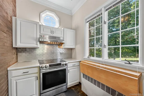 a kitchen with stainless steel appliances a stove and a white cabinets