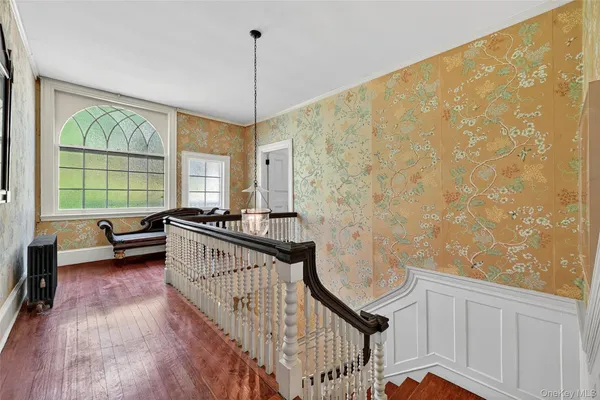 a view of a bedroom with wooden floor and windows