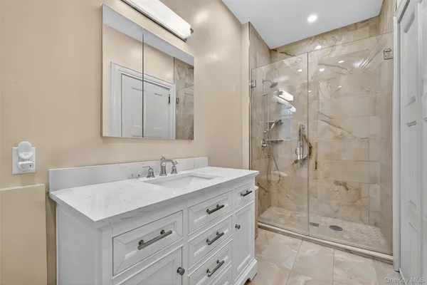 a bathroom with a shower sink and mirror