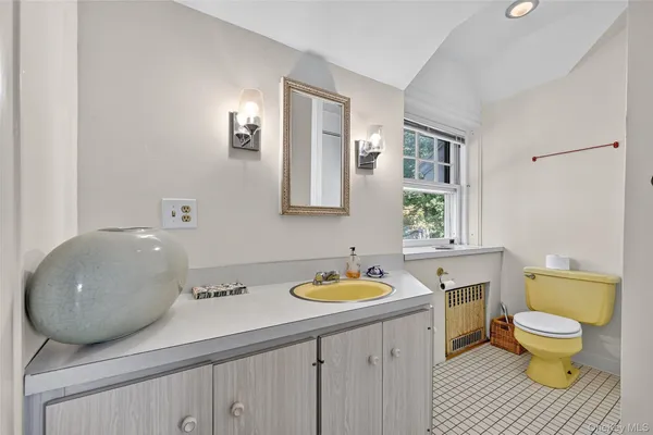 a bathroom with a granite countertop toilet a sink and a mirror