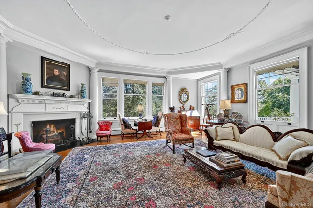 a living room with furniture fireplace and a large window