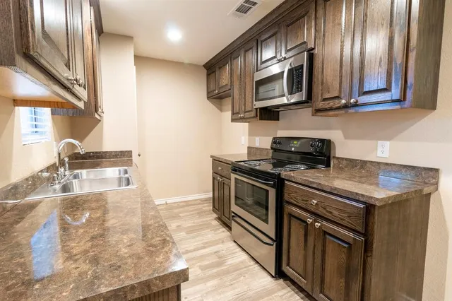a kitchen with stainless steel appliances granite countertop a stove and a microwave