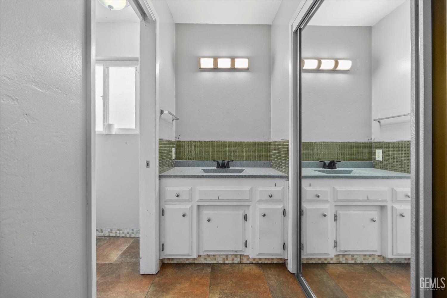 Undisclosed Address Bakersfield, CA 93309 - Photo 22 of 36 a bathroom with a granite countertop sink and a mirror