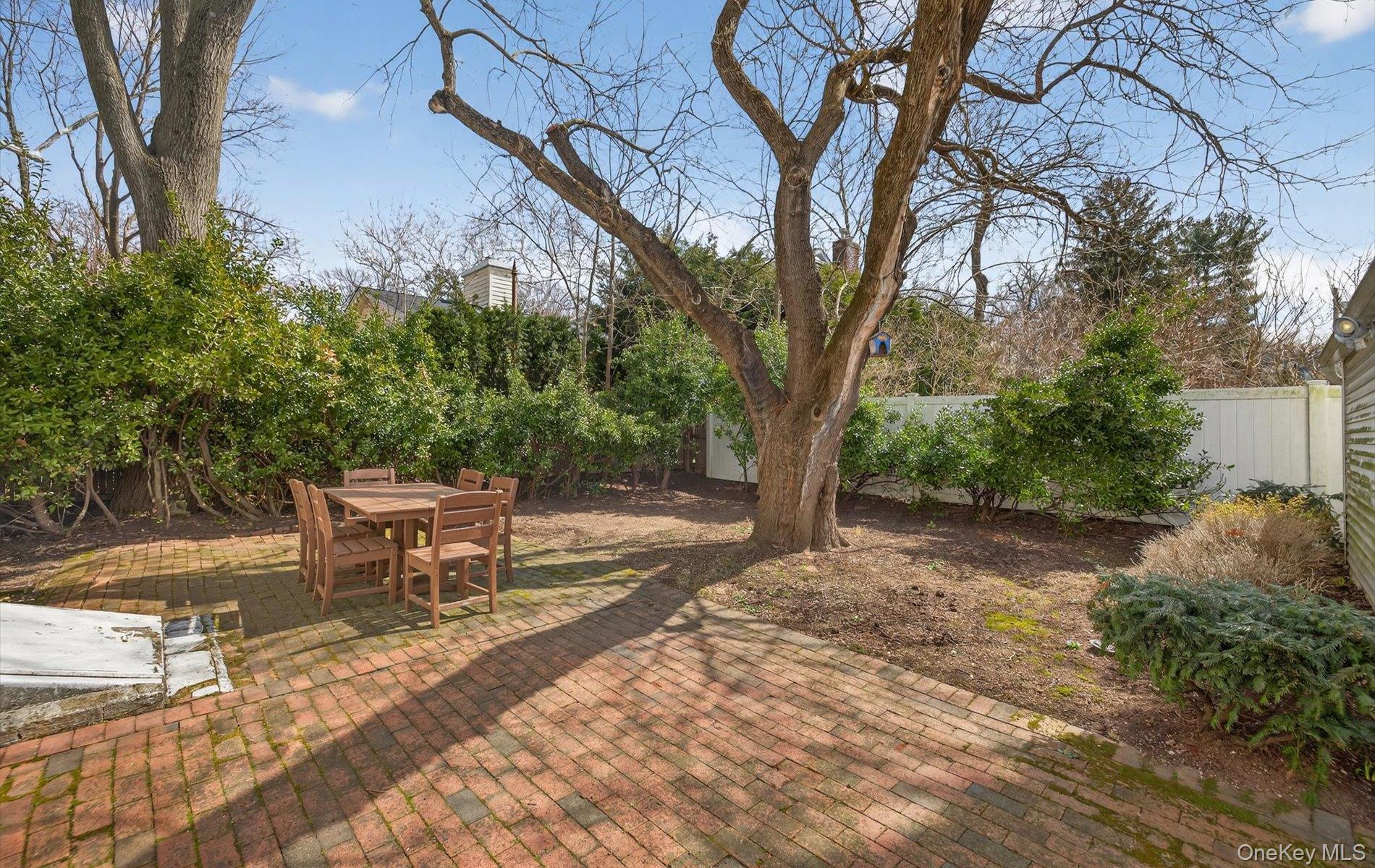 28 Harbor Road Port Washington, NY 11050 - Photo 20 of 22 a view of a backyard with table and chairs and a fire pit