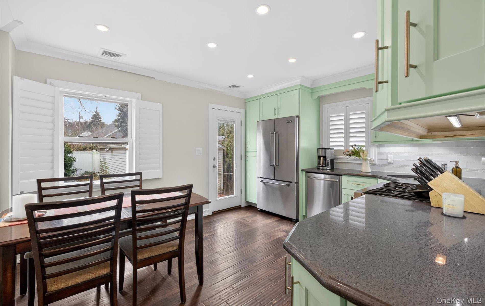 28 Harbor Road Port Washington, NY 11050 - Photo 7 of 22 a kitchen with stainless steel appliances a dining table chairs and wooden floor