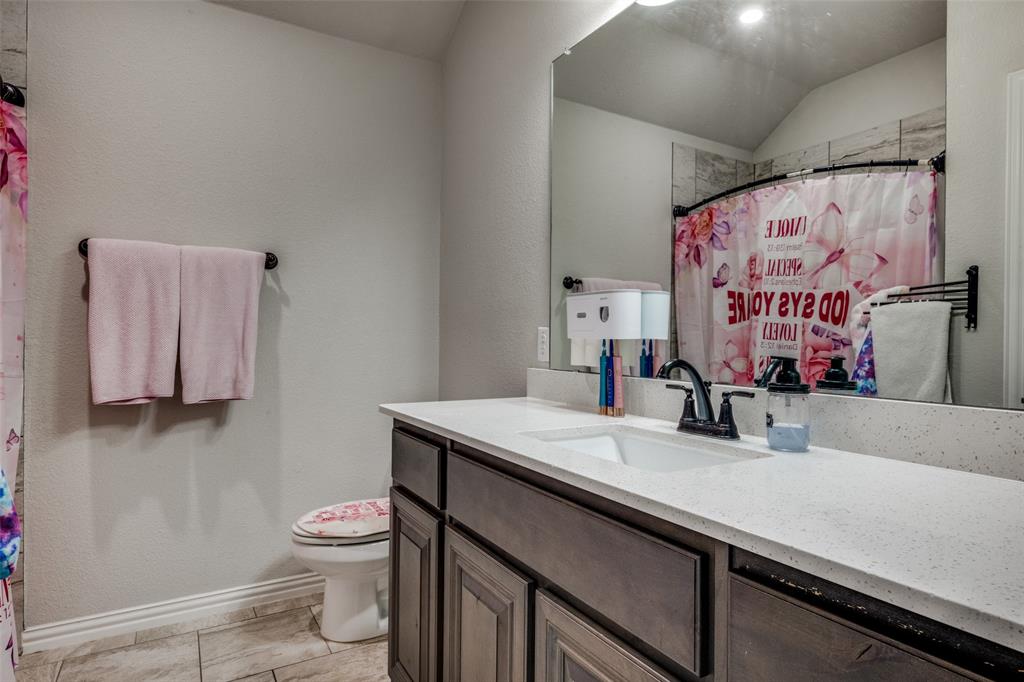 7417 Green Mesa Road Ponder, TX 76259 - Photo 27 of 39 a bathroom with a sink a toilet and mirror