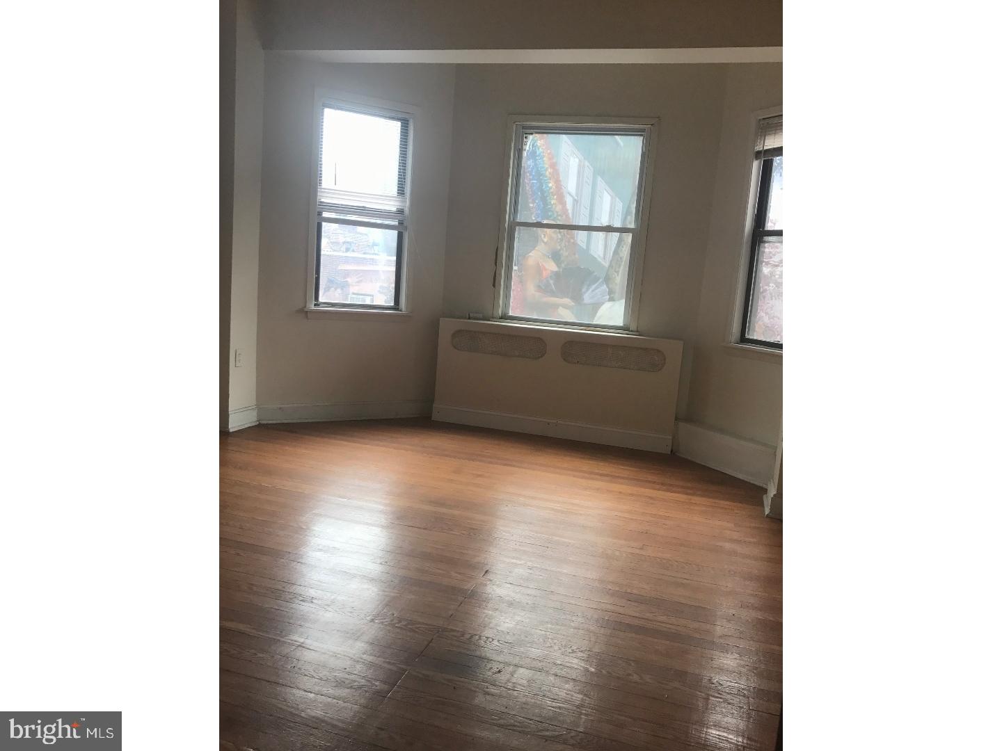 1321 Spruce Street, Unit 1E Philadelphia, PA 19107 - Photo 12 of 22 a view of an empty room with wooden floor and a window