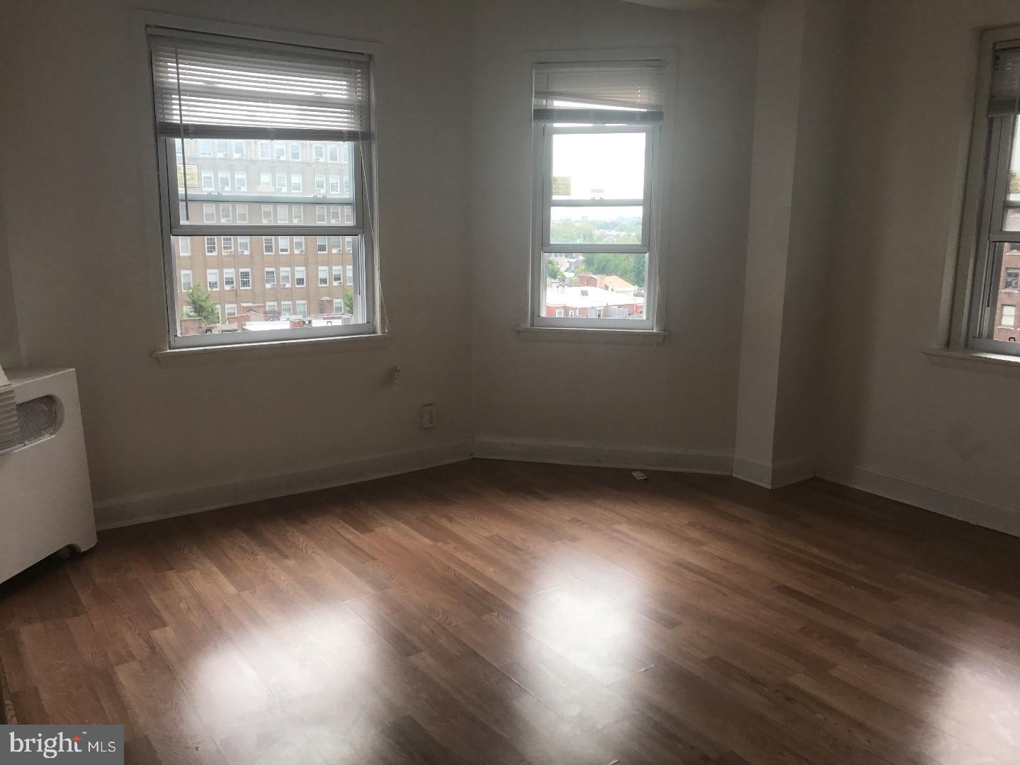 1321 Spruce Street, Unit 1E Philadelphia, PA 19107 - Photo 8 of 22 an empty room with wooden floor and windows