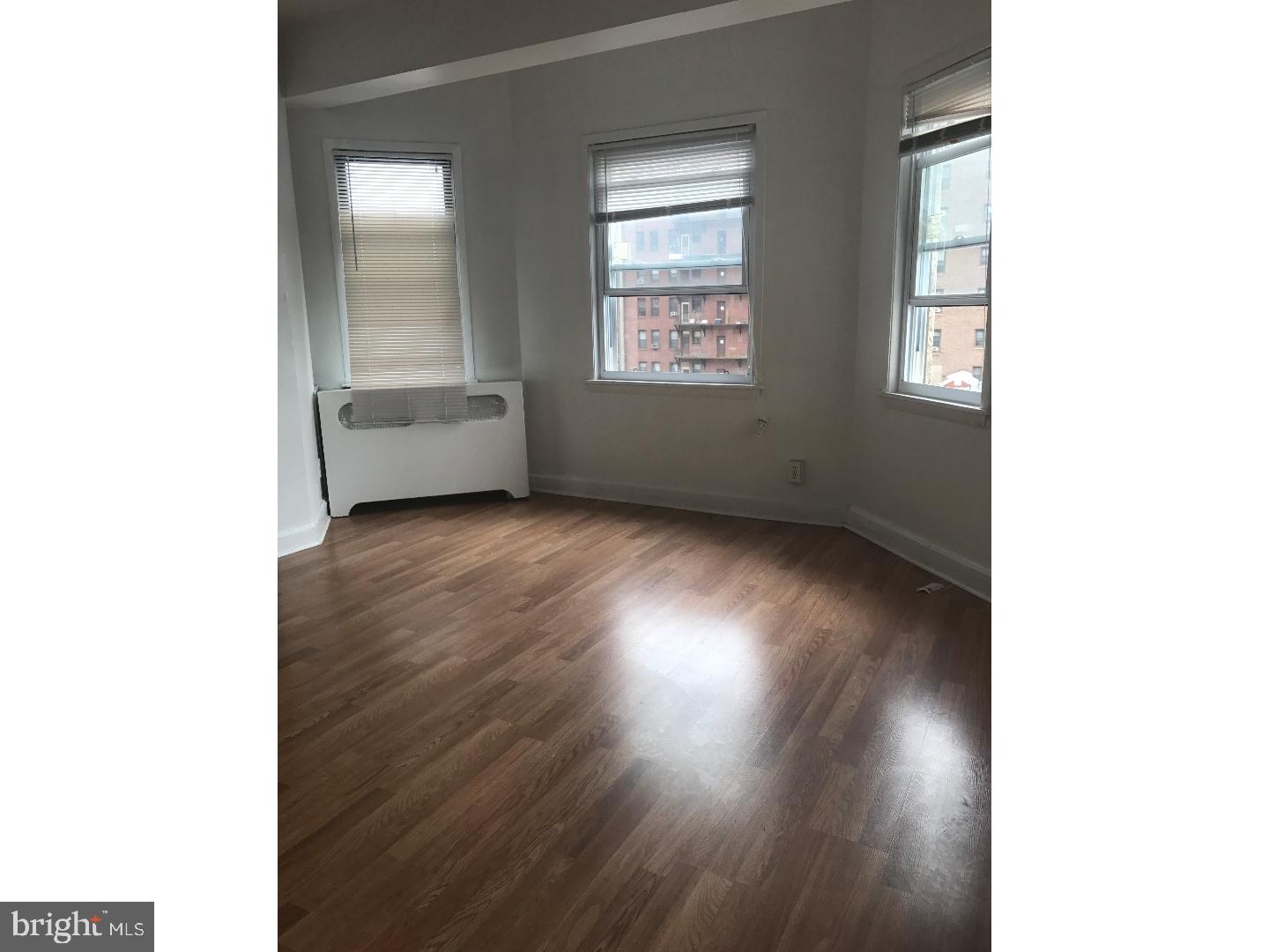 1321 Spruce Street, Unit 1E Philadelphia, PA 19107 - Photo 9 of 22 a view of an empty room with wooden floor and a window
