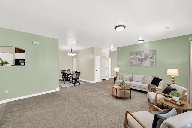 8215 Clear Rock Road, Unit 12 Eagle Mountain, UT 84005 - Photo 6 of 38 Spacious living area featuring light green and neutral wall tones, recessed ceiling lights, and grey carpeting