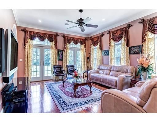 a living room with furniture a large window and a chandelier