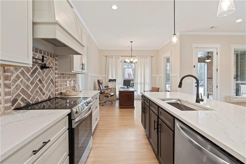301 Roy Morgan Road Carrollton, GA 30116 - Photo 11 of 35 a kitchen with stainless steel appliances granite countertop a sink stove and cabinets