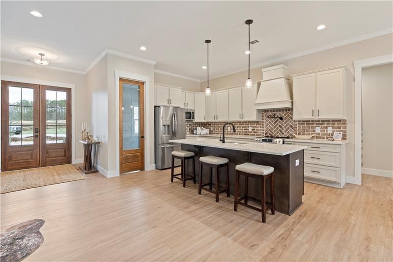 301 Roy Morgan Road Carrollton, GA 30116 - Photo 8 of 35 a open kitchen with stainless steel appliances granite countertop a stove a sink dishwasher and a refrigerator with wooden floor