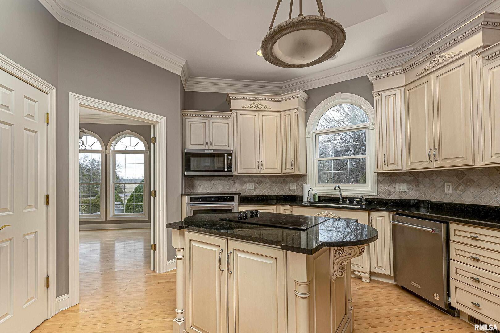 3115 West Striegel Road Carbondale, IL 62901 - Photo 20 of 54 a kitchen with granite countertop a stove a sink and a granite counter tops with white cabinets