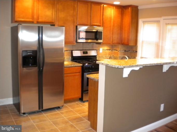 812 Wicklow Road Baltimore, MD 21229 - Photo 9 of 30 a kitchen with granite countertop a refrigerator and a stove