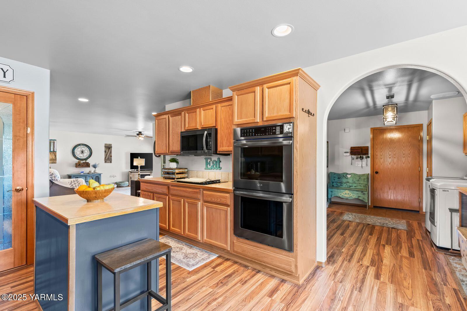 1880 Dilley Road Tieton, WA 98947 - Photo 11 of 45 a kitchen with stainless steel appliances granite countertop a refrigerator a stove top oven and sink with wooden floor
