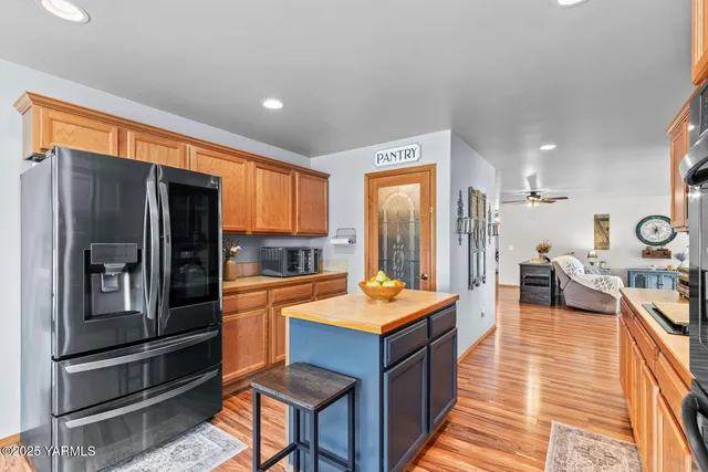 a large kitchen with stainless steel appliances granite countertop a refrigerator and a stove