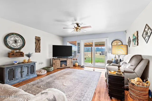 a living room with furniture a flat screen tv and a large window