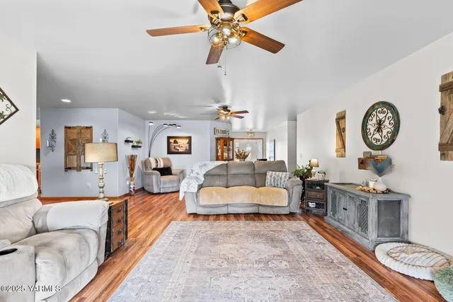 a living room with furniture a clock on wall and a chandelier