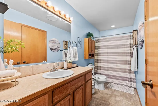 a bathroom with a double vanity sink toilet and shower