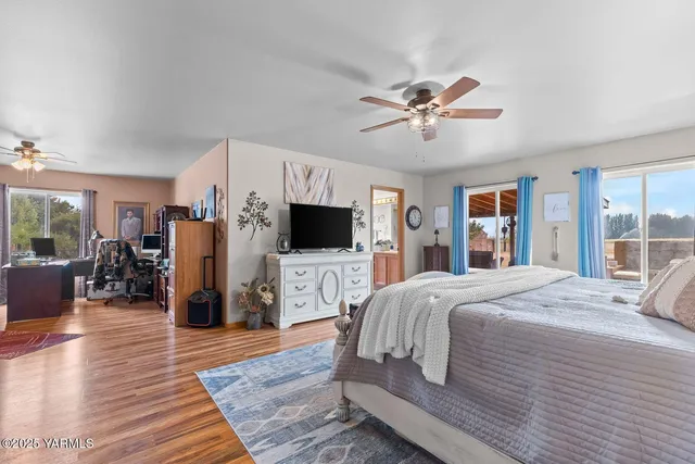 a bedroom with a bed a window and a flat screen television