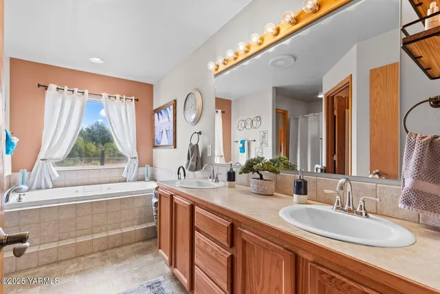 a bathroom with a granite countertop sink mirror and a bathtub