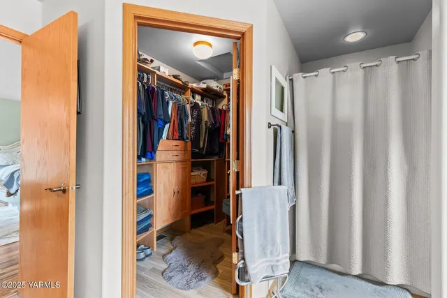 a view of walk in closet with clothes and shoes